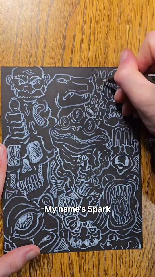 Dense white-ink doodle of interlocking monsters, skulls, frogs and teeth covering a sheet of black paper edge to edge.